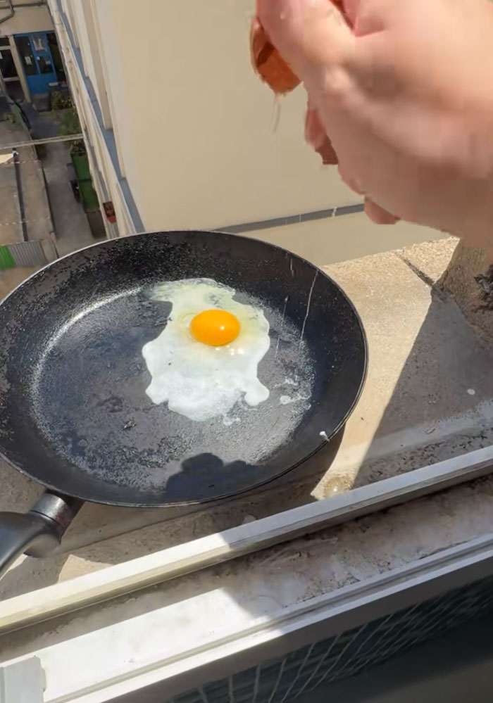 An egg frying in a pan placed on a ledge, showing how hot it is during the heatwave.
