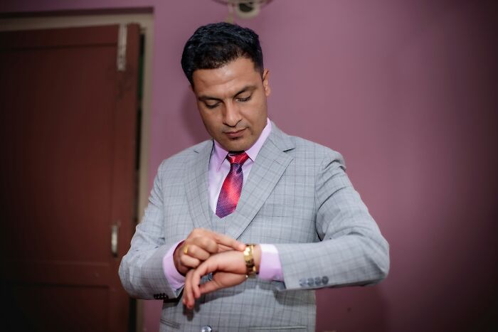 Man in gray suit checking time on wristwatch