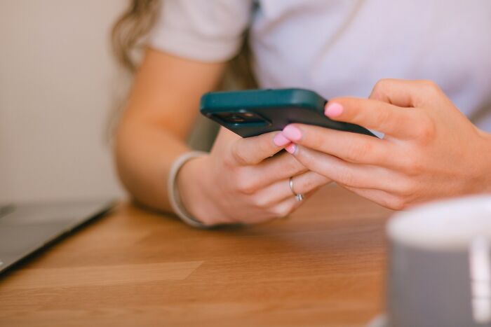 Close-up of woman holding smartphone texting
