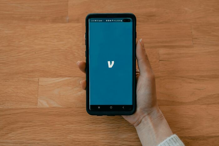 Hand holding phone with Venmo app open showing generosity payment
