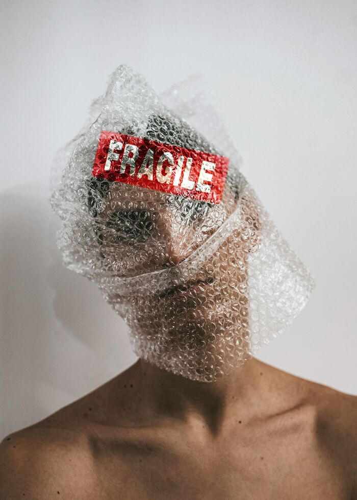 Person with bubble wrap and fragile label symbolizing anxiety vulnerability