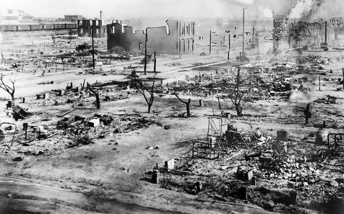 Historical photos: A desolate landscape of a bombed city with burning buildings and debris.