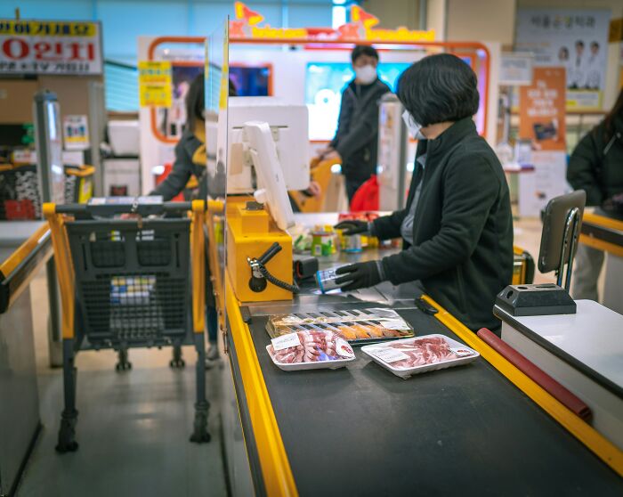Grocery checkout with cashier and packaged food highlighting AI-caused great depression effects