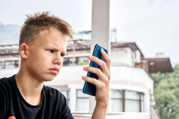 A young boy looks at his phone with a confused expression after he steals a woman's hair towel and Mommy Dearest accuses her of harassment. A young boy looks at his phone with a confused expression after he steals a woman's hair towel and Mommy Dearest accuses her of harassment.