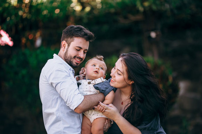 Young family enjoying time together outdoors with their baby son Young family enjoying time together outdoors with their baby son