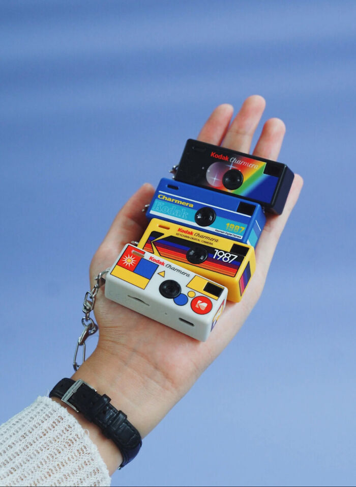 Miniature vintage-style Kodak charmers held in hand as keychains