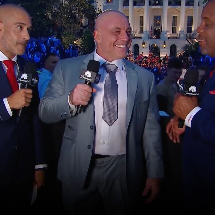 Three men in suits holding microphones and interviewing at UFC 250 event on the White House lawn