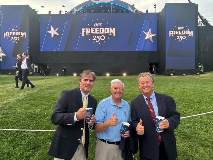 Three men giving thumbs up in front of UFC Freedom 250 stage on the White House lawn
