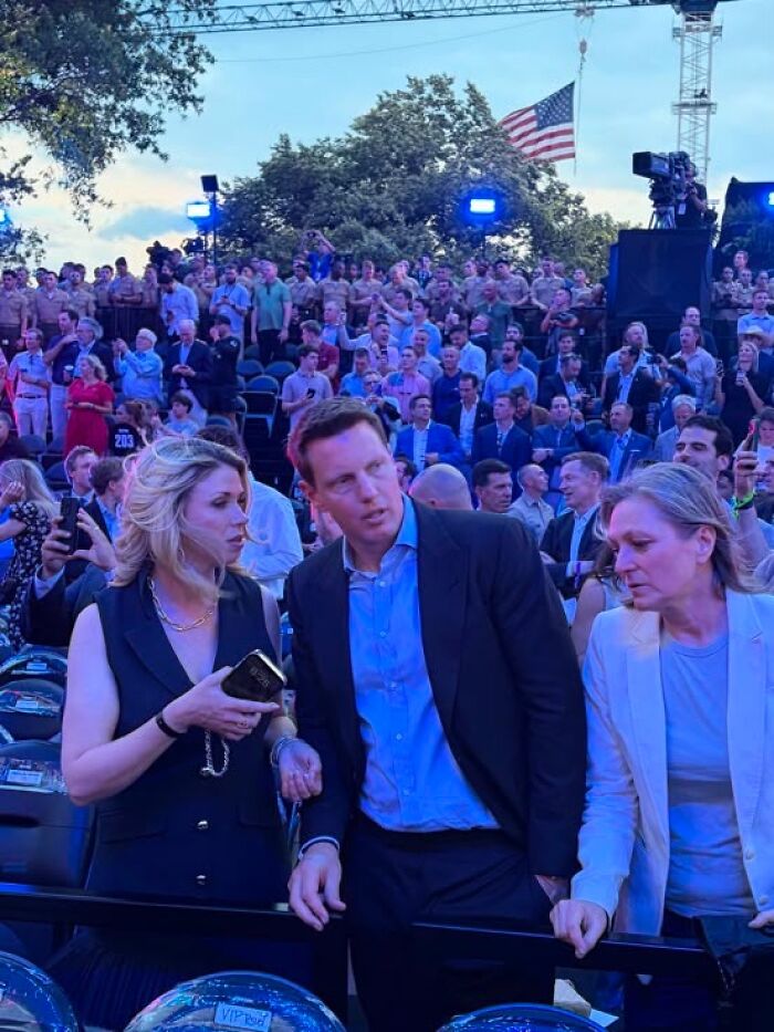 Audience watching UFC 250 fight on White House lawn with people conversing in front