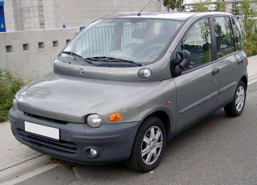 A grey Fiat Multipla, one of the ugly cars that became legendary, parked on a street.