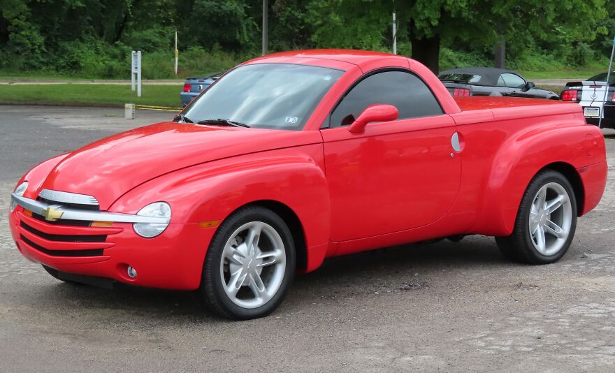 A red Chevrolet SSR, one of the ugly cars that became legendary, parked on asphalt.