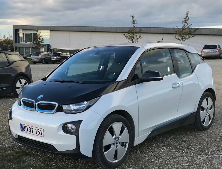 White and black BMW i3, an ugly car that became legendary, parked outdoors.