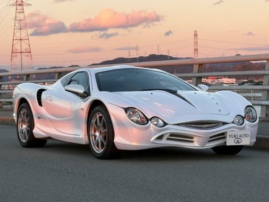 Sleek white sports car, an ugly car that became legendary, with a unique front grille.