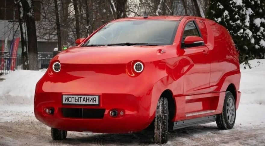 A bright red, ugly car with round headlights, parked in a snowy landscape. Legendary and unique car design.