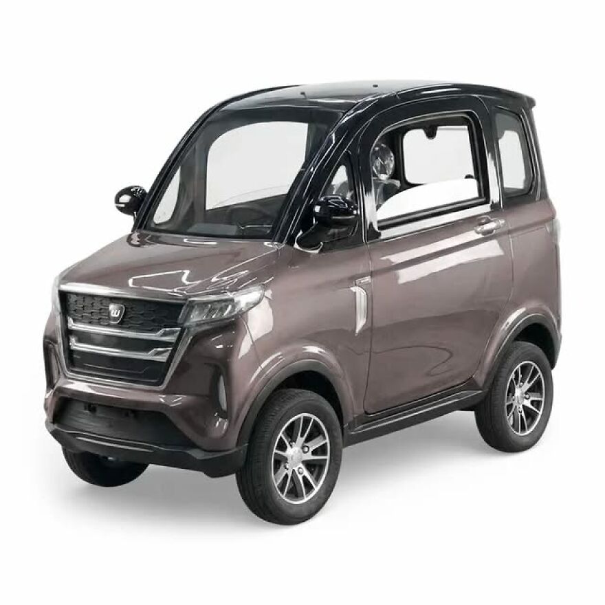 A small, compact ugly car, gray with a black roof, legendary for its unique design.