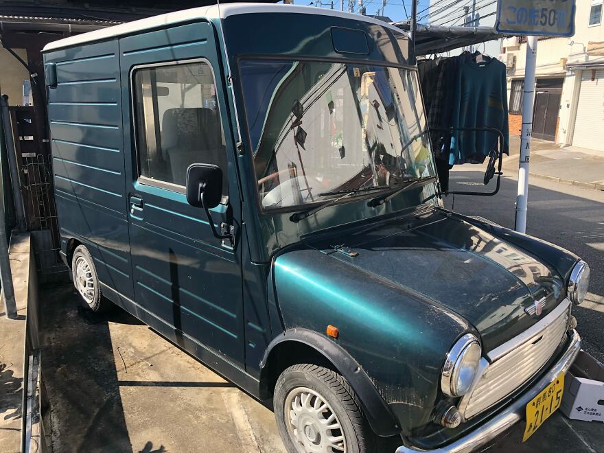 A small green ugly car, a van, parked on a street in an urban setting, a legendary ugly car.