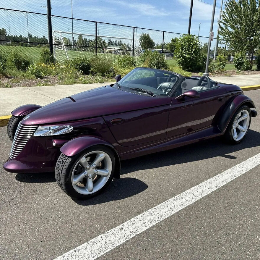 A dark purple ugly car, a convertible, parked in a lot on a sunny day, a legendary ugly car.