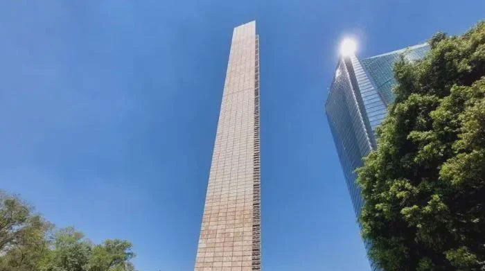 Tall narrow stone monument with blue sky background