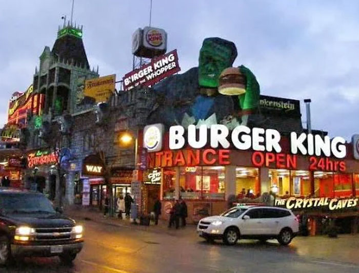 Burger King building with large green hand sculpture and bright signs