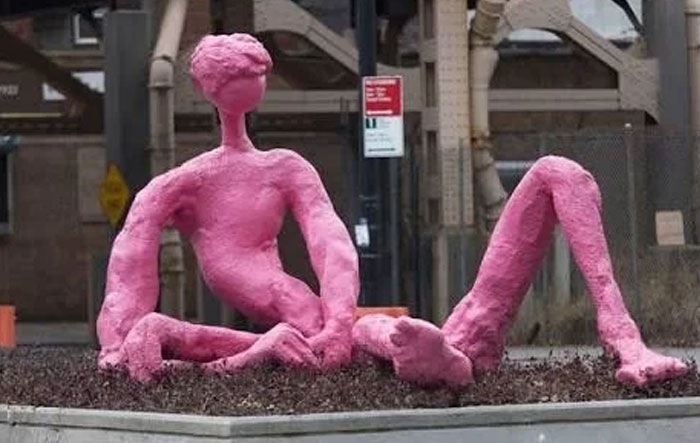 Abstract pink sculpture of distorted human figure as ugly monument