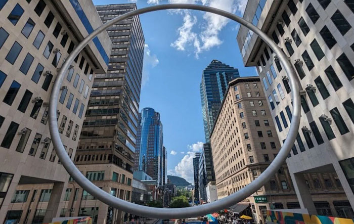Metal ring monument among city skyscrapers as ugly monuments example