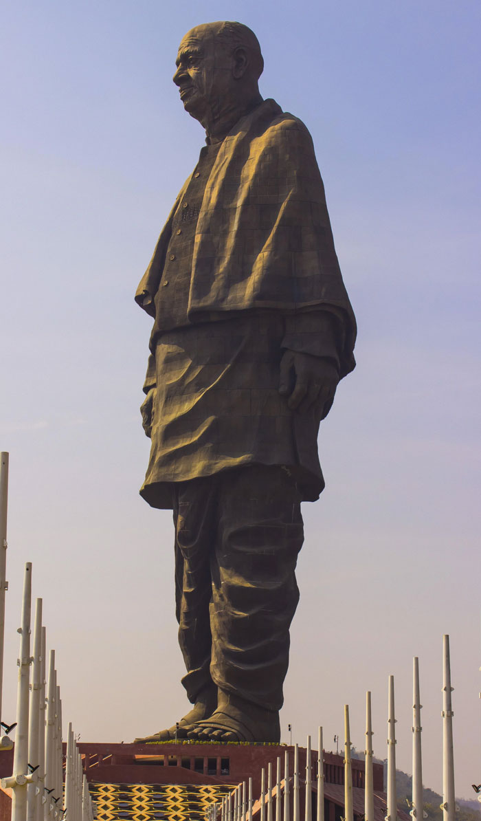 Massive statue monument of a man wearing traditional clothes at sunset