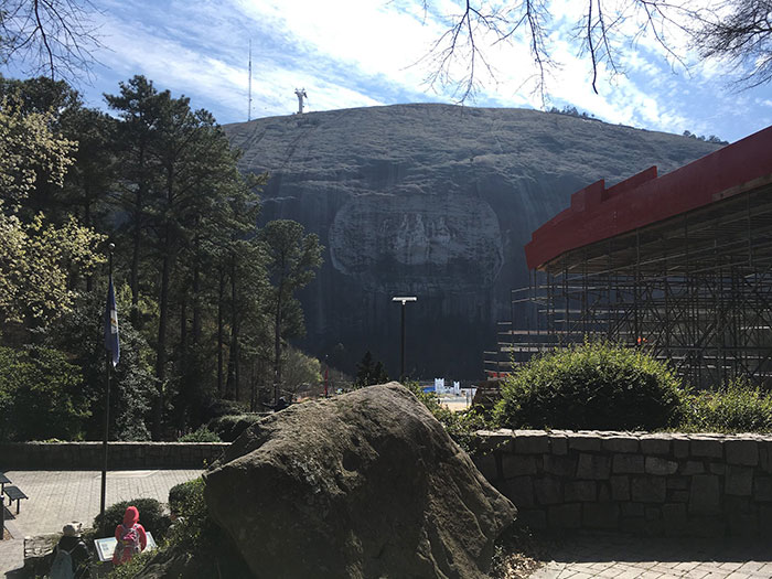 Stone Mountain monument with large face carving viewed from a park area