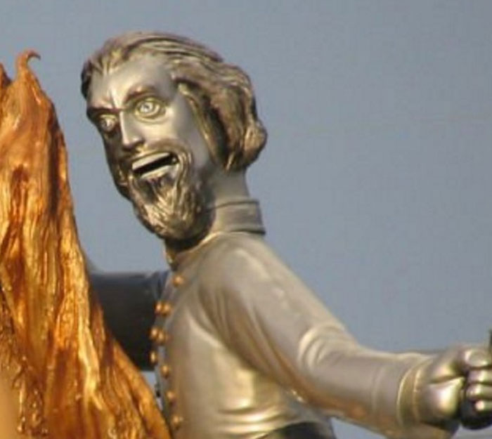 Close-up of a quirky bronze statue with exaggerated facial features