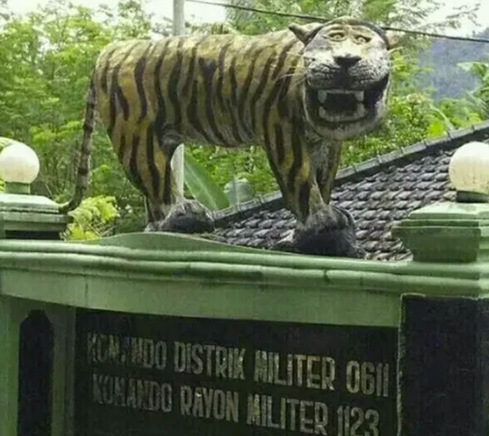 Tiger statue with awkward proportions on a building rooftop