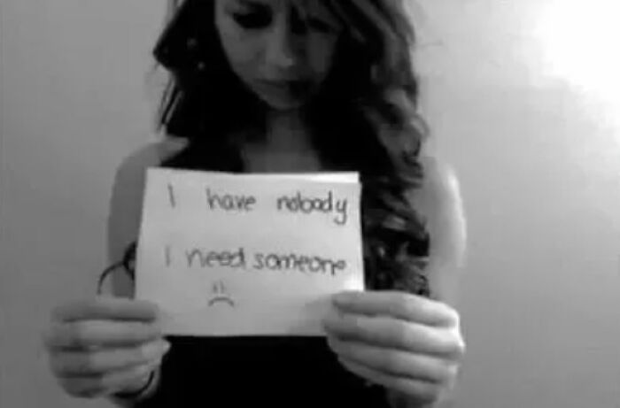 Creepy black and white image of woman holding sad note