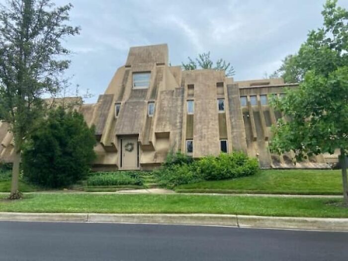 A large, unique-shaped house with a concrete-like exterior and many angles, an example of architecture and design fails.