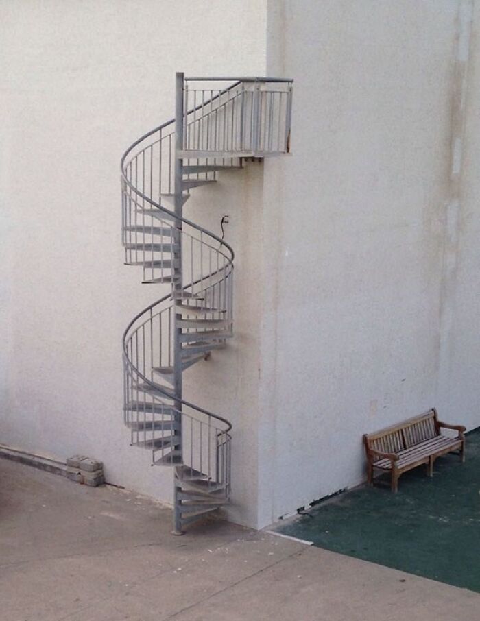 A metal spiral staircase leads to a small upper platform, an architecture fail that could have been avoided.