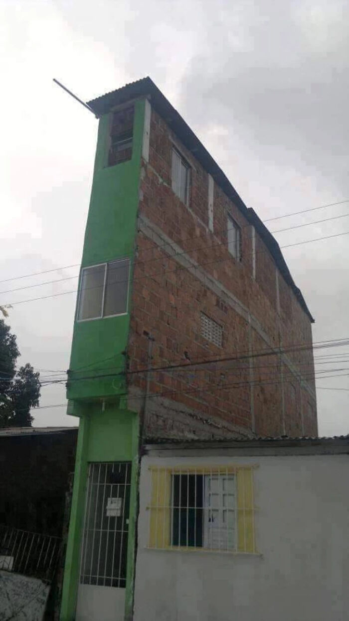 A narrow, tall building with a green facade, illustrating significant architecture and design fails.