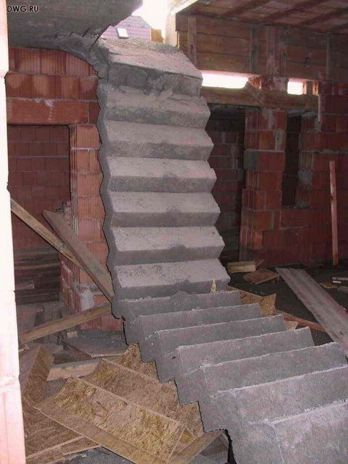 A design fail with a spiral concrete staircase that appears to be collapsing into debris during construction.