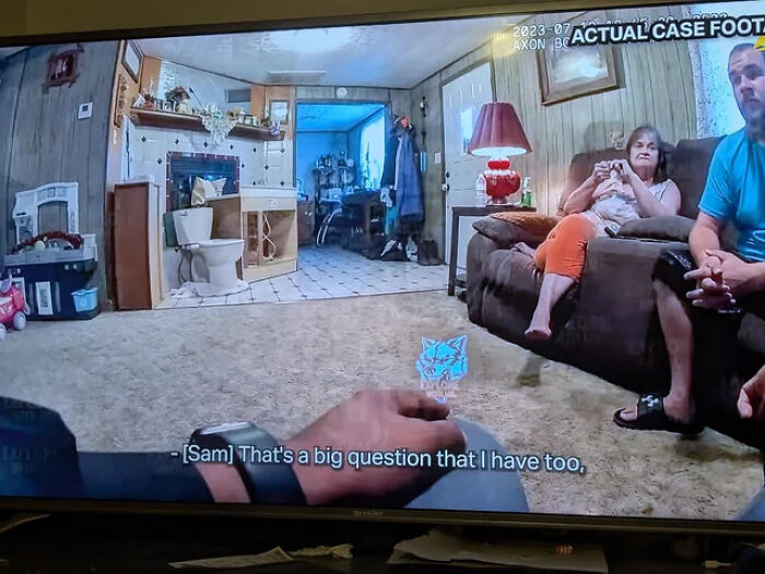 A television screen showing a living room with a toilet in the corner, illustrating an architecture design fail.