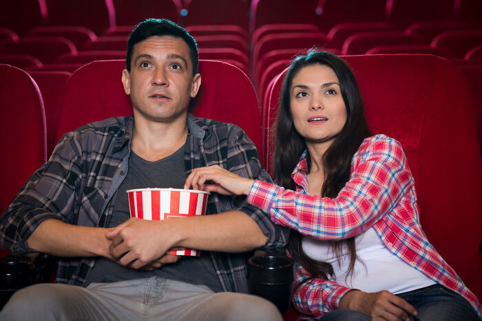 Couple watching movie together in theater