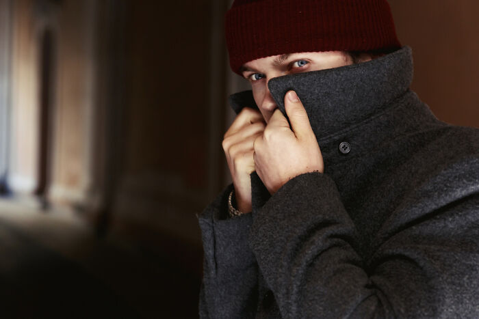 Mysterious man hiding face in coat depicting troubled relationship
