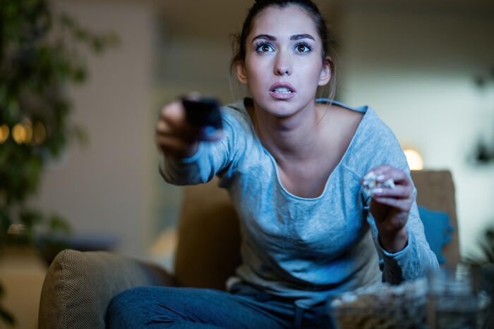 Woman watching TV intensely, symbolizing relationships that derailed and breakup stories
