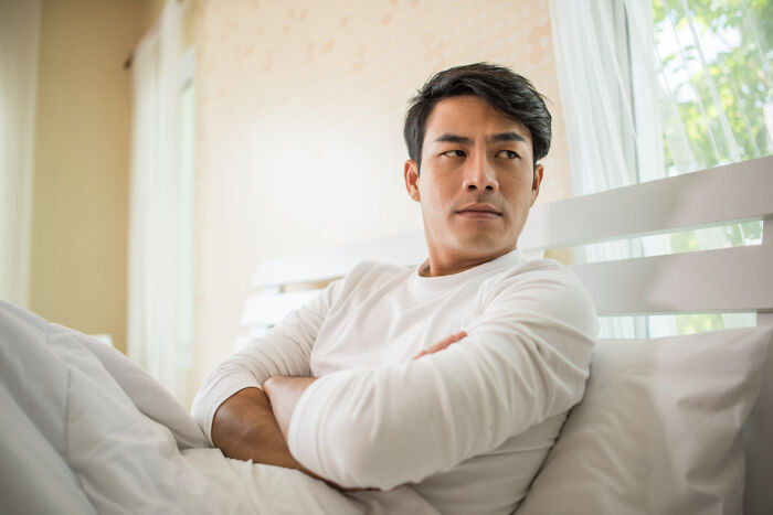 Man looking upset in bed illustrating relationship breakup struggles