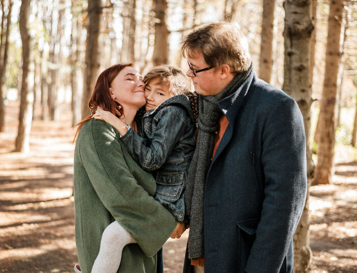 Happy family enjoying time in autumn forest with affectionate relationships
