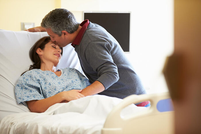 Man kissing woman in hospital bed, reflecting relationships that derailed and breakup stories