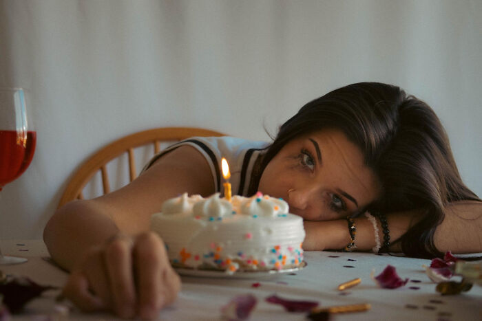 Woman looking sad with birthday cake showing emotional breakup moments