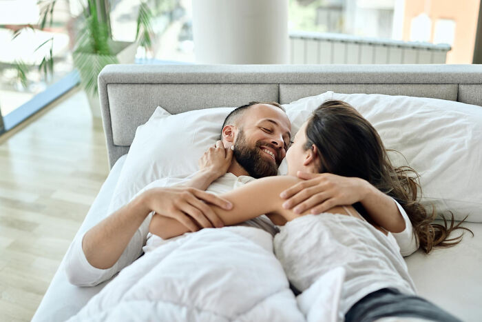 Couple embracing intimately in bed showing strong relationship bond