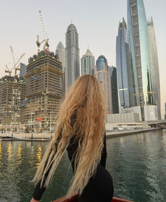 A high-class intimate companion overlooks a cityscape, hinting at the lavish lifestyle of wealthy World Cup players.