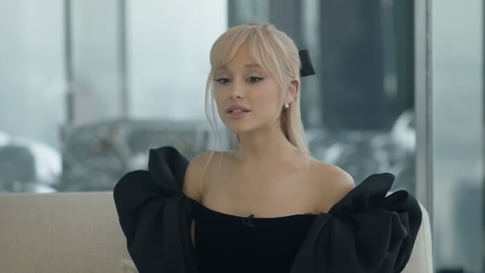 Female celebrity with blonde hair, bangs, and a black off-the-shoulder top, looking contemplative, whose fame ran out.