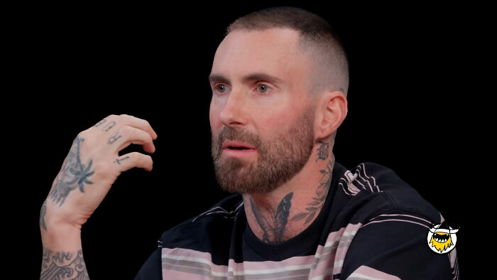 Adam Levine speaks in an interview, a figure in celebrity scandals.