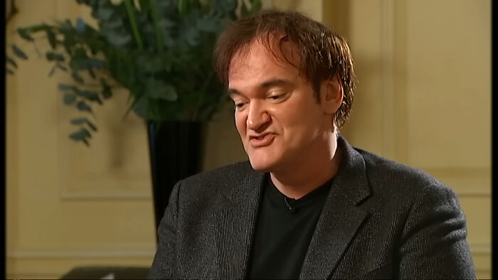 Quentin Tarantino speaking during an interview, contributing to discussions on celebrity scandals.