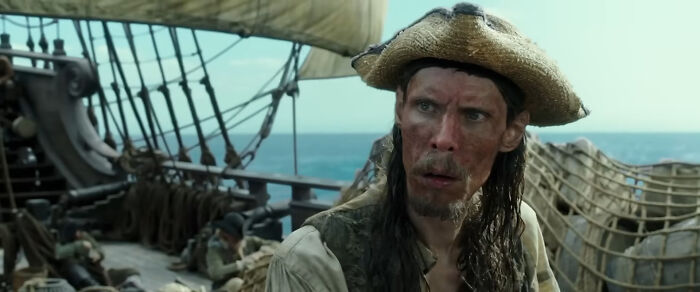 A pirate character from Pirates of the Caribbean looking at something with a worried expression on a ship at sea. A pirate character from Pirates of the Caribbean looking at something with a worried expression on a ship at sea.