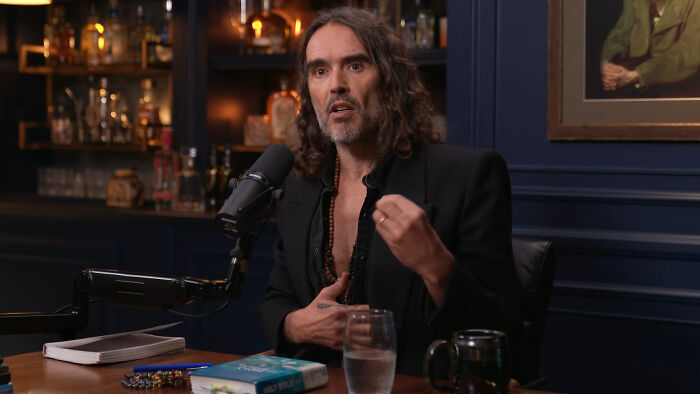Celebrity with long hair and beard, wearing a dark jacket, speaking into a microphone. Has this celebritys fame run out?