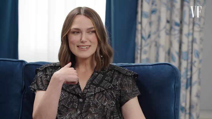 Keira Knightley, star of Pirates of the Caribbean, smiling and talking while sitting on a blue couch. Keira Knightley, star of Pirates of the Caribbean, smiling and talking while sitting on a blue couch.